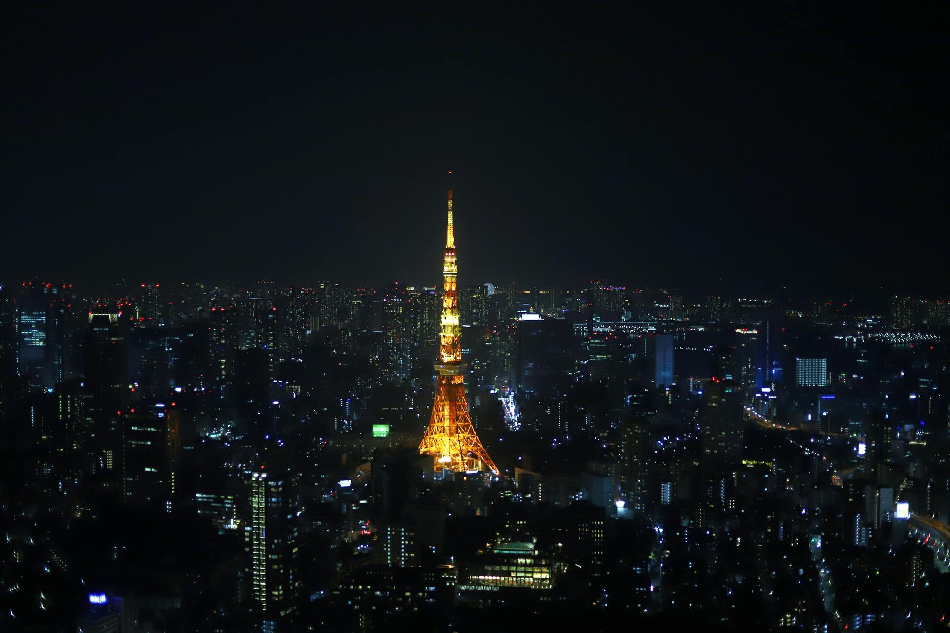 tokyo tower illuminated against night sky
